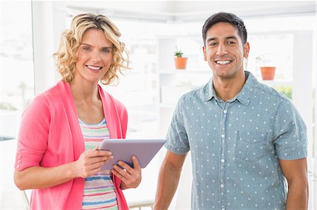 simsearch:6109-08203934,k - Portrait of smiling colleagues with tablet computer looking at camera Stock Photo - Premium Royalty-Free, Code: 6109-08203925