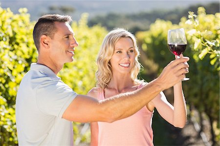 simsearch:6109-08204218,k - Smiling couple doing wine tasting next to grapevine Stock Photo - Premium Royalty-Free, Code: 6109-08204006