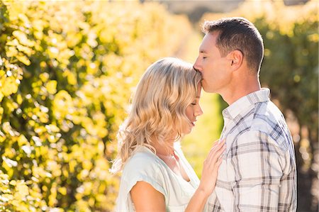 simsearch:6109-08204218,k - Man kissing his woman on forehead with eyes closed next to grapevine Stock Photo - Premium Royalty-Free, Code: 6109-08204021
