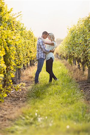 simsearch:6109-08204218,k - Couple embracing and being about to kiss between grapevine Stock Photo - Premium Royalty-Free, Code: 6109-08204027