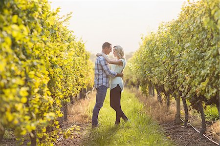 simsearch:6109-08204218,k - Couple embracing and being about to kiss between grapevine Stock Photo - Premium Royalty-Free, Code: 6109-08204028