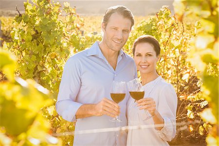 simsearch:6109-08204218,k - Smiling couple toasting with red wine Stock Photo - Premium Royalty-Free, Code: 6109-08204243