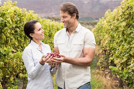 simsearch:6109-08204218,k - Smiling couple looking at a bunch of red grape Stock Photo - Premium Royalty-Free, Code: 6109-08204219
