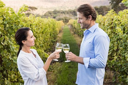 simsearch:6109-08204218,k - Smiling couple toasting with white wine Stock Photo - Premium Royalty-Free, Code: 6109-08204236