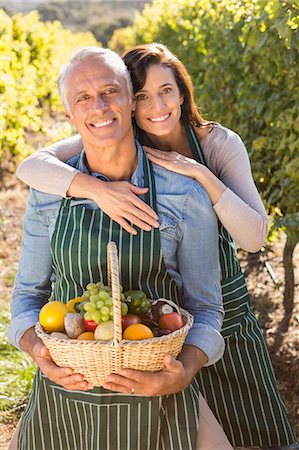 simsearch:6109-08204218,k - Smiling couple holding basket with fruits Stock Photo - Premium Royalty-Free, Code: 6109-08204331