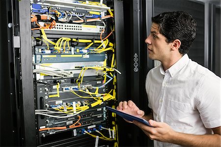 system - Technician using tablet pc while analysing server Stock Photo - Premium Royalty-Free, Code: 6109-08389842