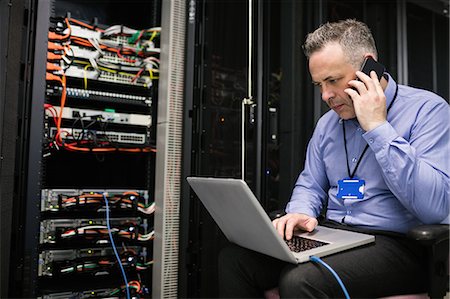 simsearch:6109-06685044,k - Technician using laptop in server room Stock Photo - Premium Royalty-Free, Code: 6109-08389951