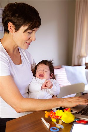 simsearch:6109-08390041,k - Mother holding her baby and using laptop Stock Photo - Premium Royalty-Free, Code: 6109-08390037