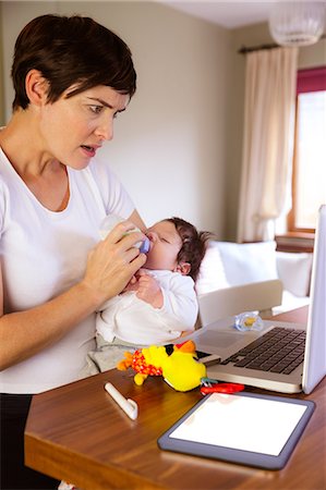 simsearch:6109-08390041,k - Mother feeding her baby and using laptop Stock Photo - Premium Royalty-Free, Code: 6109-08390038
