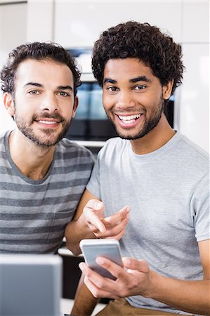 simsearch:6109-08390293,k - Smiling gay couple using smartphone in kitchen Stock Photo - Premium Royalty-Free, Code: 6109-08390264