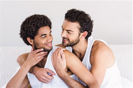 Smiling gay couple hugging on bed Stock Photo - Premium Royalty-Free, Code: 6109-08390398