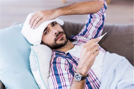 Sick man checking temperature Stock Photo - Premium Royalty-Free, Code: 6109-08390490