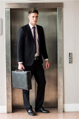 simsearch:6109-06684997,k - Businessman holding portfolio in front of a elevator Stock Photo - Premium Royalty-Free, Code: 6109-08394961