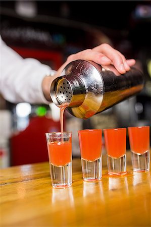 Bartender pouring cocktail into glasses Stock Photo - Premium Royalty-Free, Code: 6109-08394910