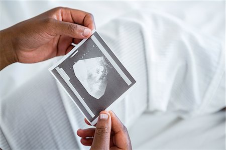 Pregnant woman holding ultrasound in hand Stock Photo - Premium Royalty-Free, Code: 6109-08395302