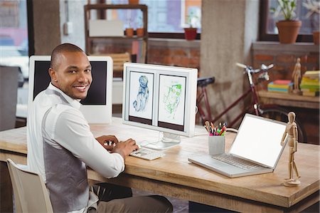 Smiling cartoonist working on computer Stock Photo - Premium Royalty-Free, Code: 6109-08395505