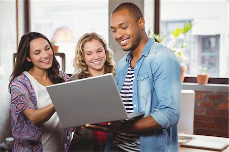 studio creative group - Man showing laptop to female colleagues at office Stock Photo - Premium Royalty-Free, Code: 6109-08395699