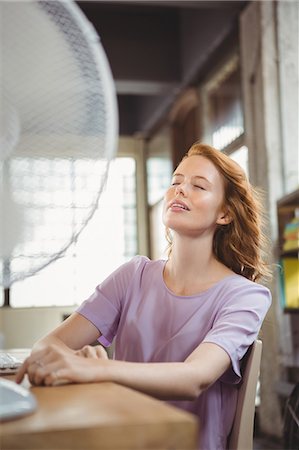 fan - Relaxed woman sitting in front of electric fan Stock Photo - Premium Royalty-Free, Code: 6109-08395818