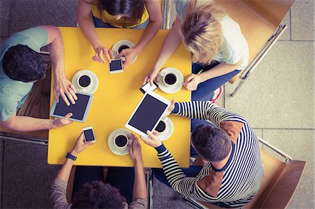 Students using smartphones and tablets in the cafe Stock Photo - Premium Royalty-Free, Code: 6109-08395923