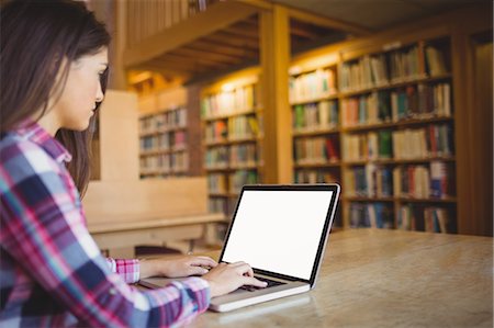 Female student using laptop in library Stock Photo - Premium Royalty-Free, Code: 6109-08396212