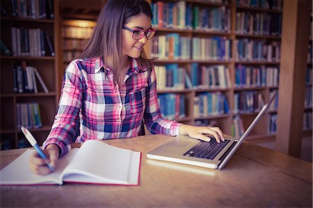 simsearch:400-04860880,k - Female student with book using laptop Stock Photo - Premium Royalty-Free, Code: 6109-08396222