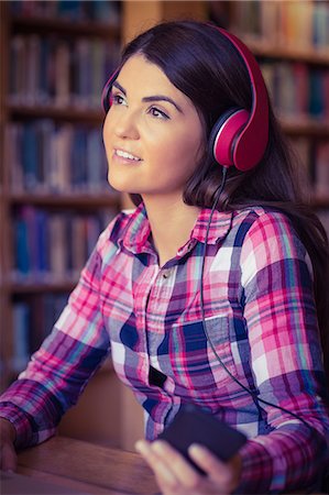 Thoughtful female student listening music Stock Photo - Premium Royalty-Free, Code: 6109-08396237