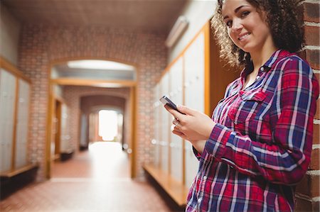 Pretty student sending a text message Stock Photo - Premium Royalty-Free, Code: 6109-08396347