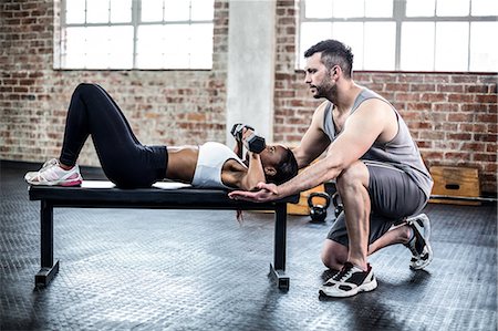 simsearch:6109-08398593,k - Personal trainer working with client holding dumbbell Stock Photo - Premium Royalty-Free, Code: 6109-08396911