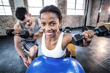 simsearch:6109-08398593,k - Personal trainer working with client holding dumbbell Stock Photo - Premium Royalty-Free, Code: 6109-08396917