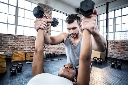 simsearch:400-05268701,k - Personal trainer working with client holding dumbbell Foto de stock - Sin royalties Premium, Código: 6109-08396914