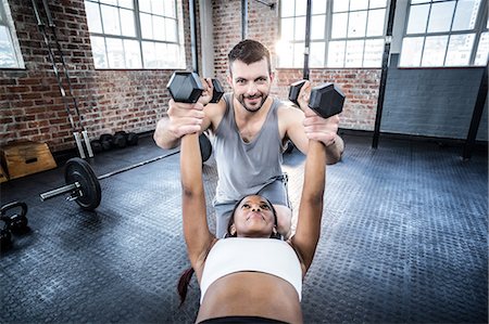 simsearch:6109-07497839,k - Personal trainer working with client holding dumbbell Stock Photo - Premium Royalty-Free, Code: 6109-08396915