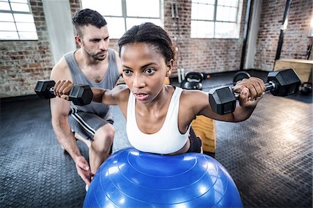 simsearch:6109-07497839,k - Personal trainer working with client holding dumbbell Stock Photo - Premium Royalty-Free, Code: 6109-08396916