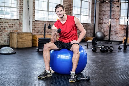 Young man exercising with dumbbell Stock Photo - Premium Royalty-Free, Code: 6109-08397163