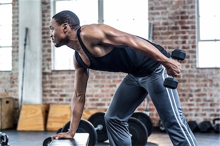 dumbbell - Muscular man doing dumbbell exercises Stock Photo - Premium Royalty-Free, Code: 6109-08397110