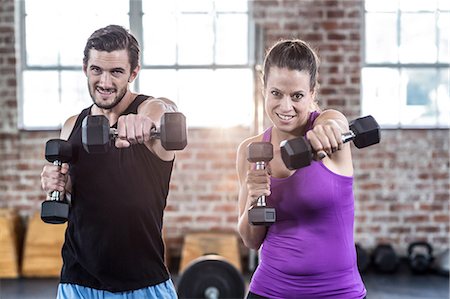 friends lifting someone - Smiling fit people lifting dumbbells Stock Photo - Premium Royalty-Free, Code: 6109-08397122