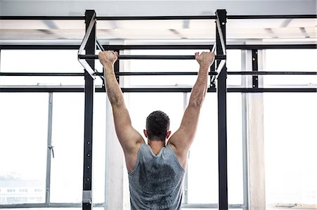 simsearch:6109-08397867,k - Fit man doing pull ups in fitness studio Stock Photo - Premium Royalty-Free, Code: 6109-08397770