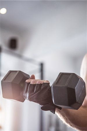 simsearch:6109-08397867,k - Fit man lifting heavy black dumbbell Stock Photo - Premium Royalty-Free, Code: 6109-08397850