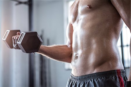 simsearch:6109-08397867,k - Fit man lifting heavy black dumbbell Stock Photo - Premium Royalty-Free, Code: 6109-08397852