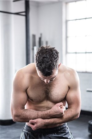 Fit man flexing his biceps Stock Photo - Premium Royalty-Free, Code: 6109-08397820