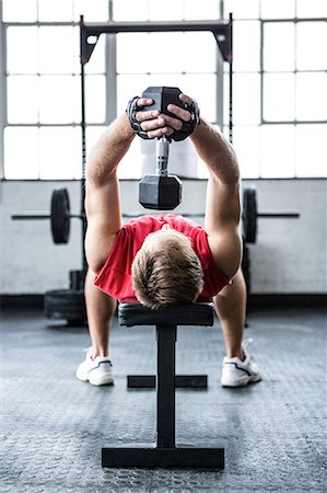 simsearch:6109-08397871,k - Fit man lifting heavy black dumbbell Stock Photo - Premium Royalty-Free, Code: 6109-08397837
