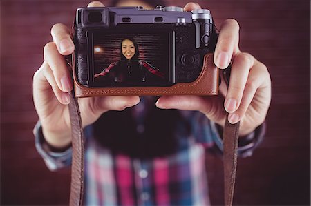 Attractive smiling hipster doing a selfie Stock Photo - Premium Royalty-Free, Code: 6109-08398215