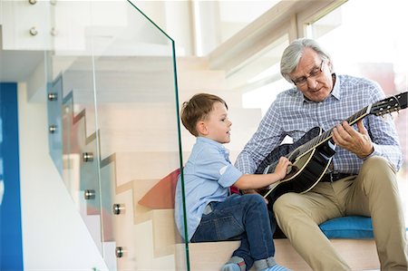 playing music - Grandfather playing guitar with grandson Stock Photo - Premium Royalty-Free, Code: 6109-08398840