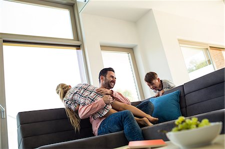 dad with kids - Father tickling daughter on the couch Stock Photo - Premium Royalty-Free, Code: 6109-08398812