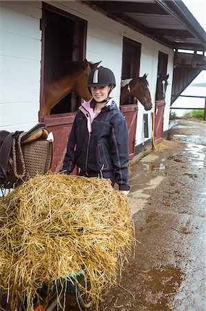 Female rider with wheelbarrow and straw Stock Photo - Premium Royalty-Free, Code: 6109-08399500