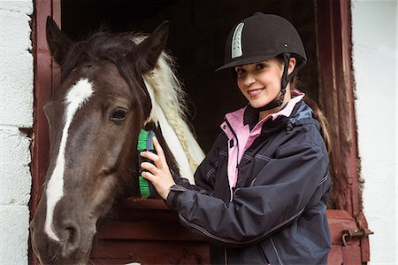 Female rider brushing her horse Stock Photo - Premium Royalty-Free, Code: 6109-08399507