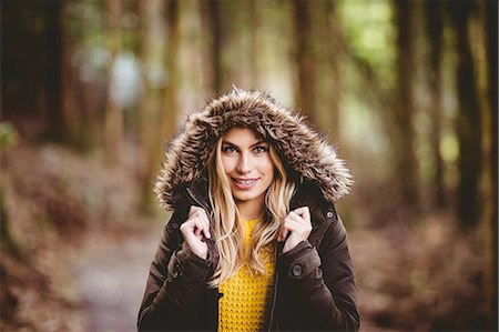 simsearch:6109-08481688,k - Beautiful blonde woman wearing hooded jumper in the woods Photographie de stock - Premium Libres de Droits, Code: 6109-08481670