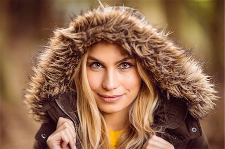 simsearch:6109-08481688,k - Beautiful blonde woman wearing hooded jumper in the woods Photographie de stock - Premium Libres de Droits, Code: 6109-08481671