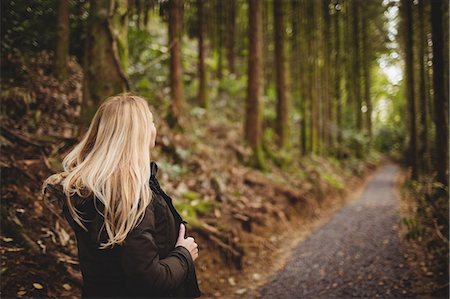simsearch:6109-08481688,k - Beautiful blonde woman walking on road surrounded by forest Photographie de stock - Premium Libres de Droits, Code: 6109-08481680