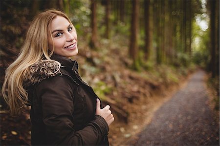 simsearch:6109-08481688,k - Beautiful blonde woman walking on road surrounded by forest Photographie de stock - Premium Libres de Droits, Code: 6109-08481681