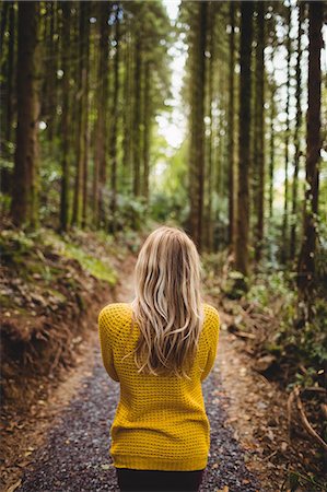 simsearch:6109-08481688,k - Beautiful blonde woman walking on road surrounded by forest Photographie de stock - Premium Libres de Droits, Code: 6109-08481689